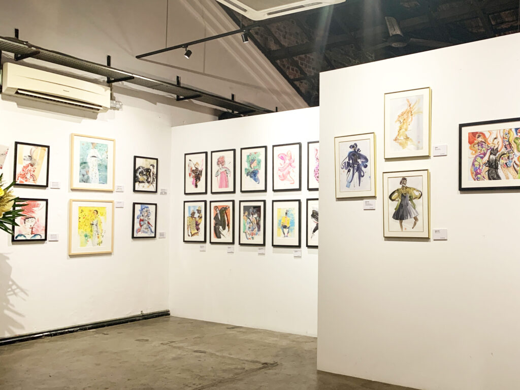 Installation view of the Busana Malaysia exhibition: framed fashion illustrations of Malaysian designers' traditional costume reinterpretations, hung on a white gallery wall.